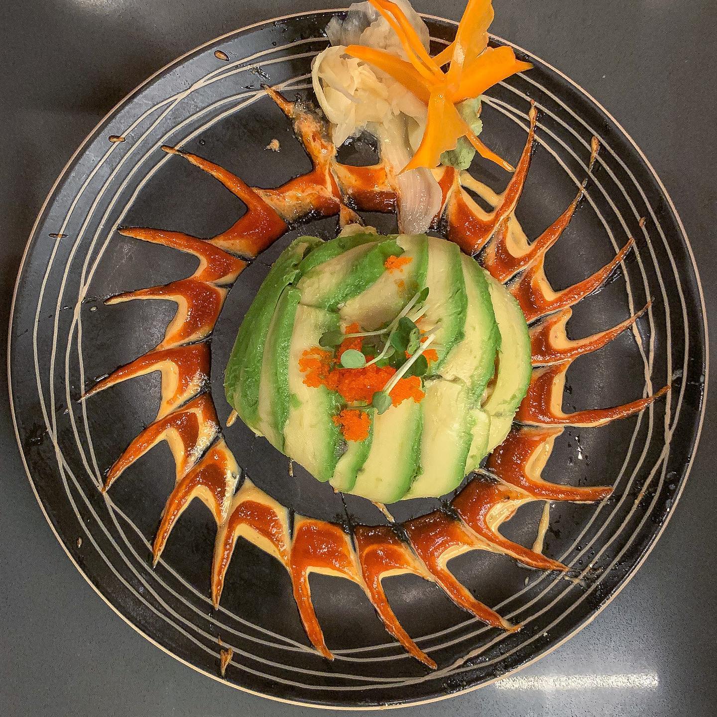 Artistic avocado sunflower sushi presentation with eel sauce at Jinbeh