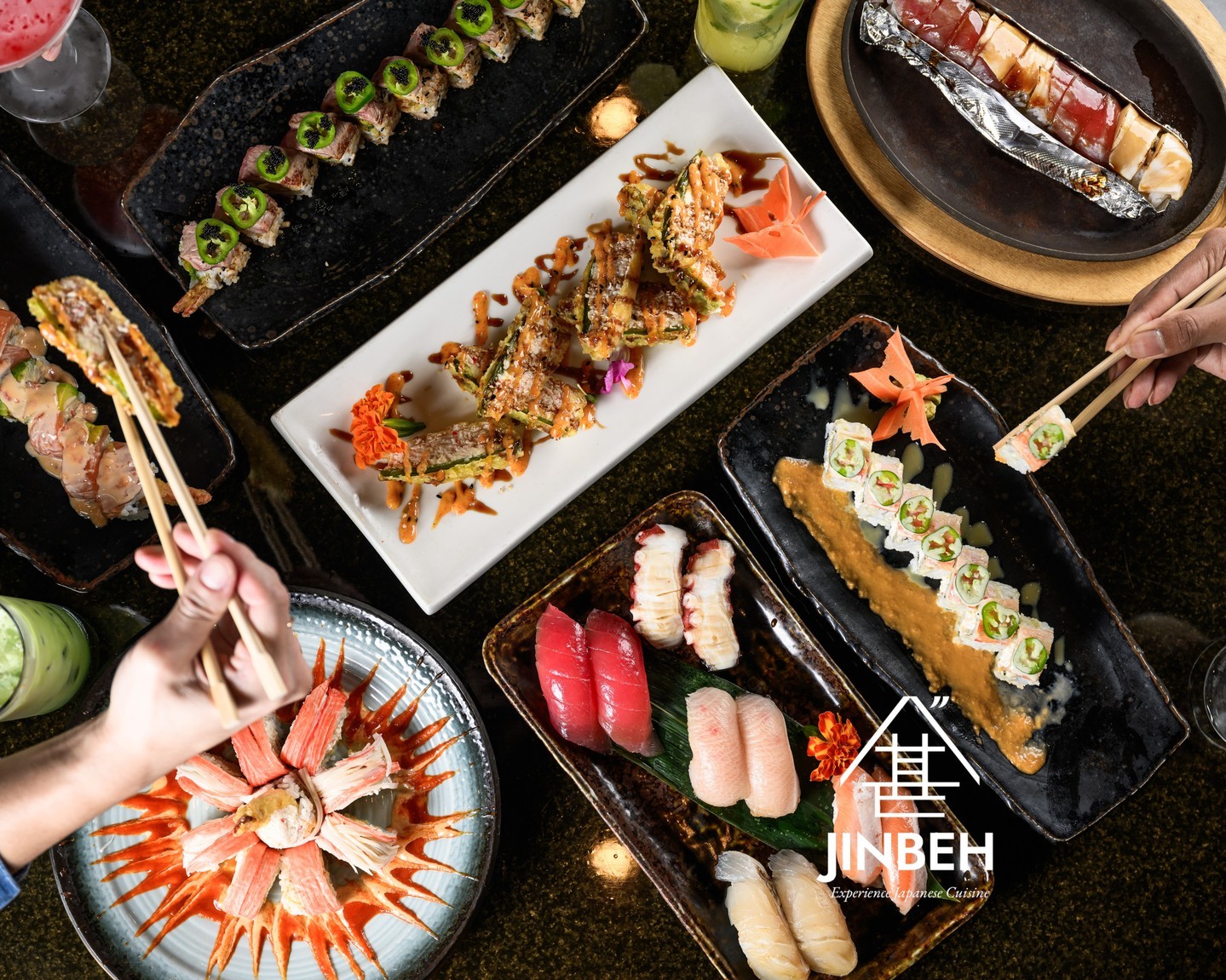 Sushi and sashimi feast flat-lay with nigiri, specialty rolls, and guests enjoying with chopsticks at Jinbeh