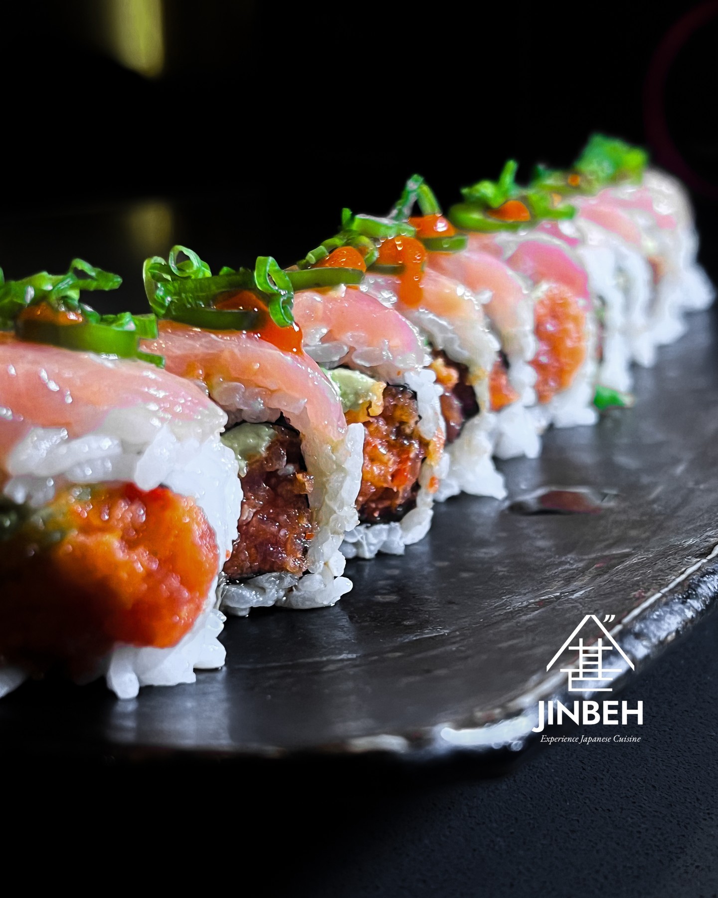 Signature specialty roll with salmon, jalapeΓ±o, tobiko at Jinbeh Japanese Restaurant