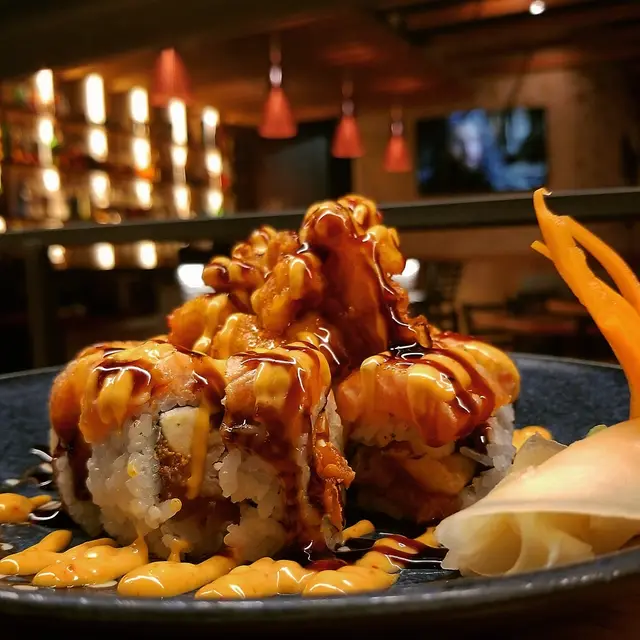 Deep-fried specialty roll with spicy mayo and eel sauce at Jinbeh sushi bar
